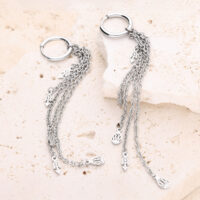 Pendientes de plata con colgante de cadena Dos pendientes de plata con cadenas colgantes sobre piedra clara