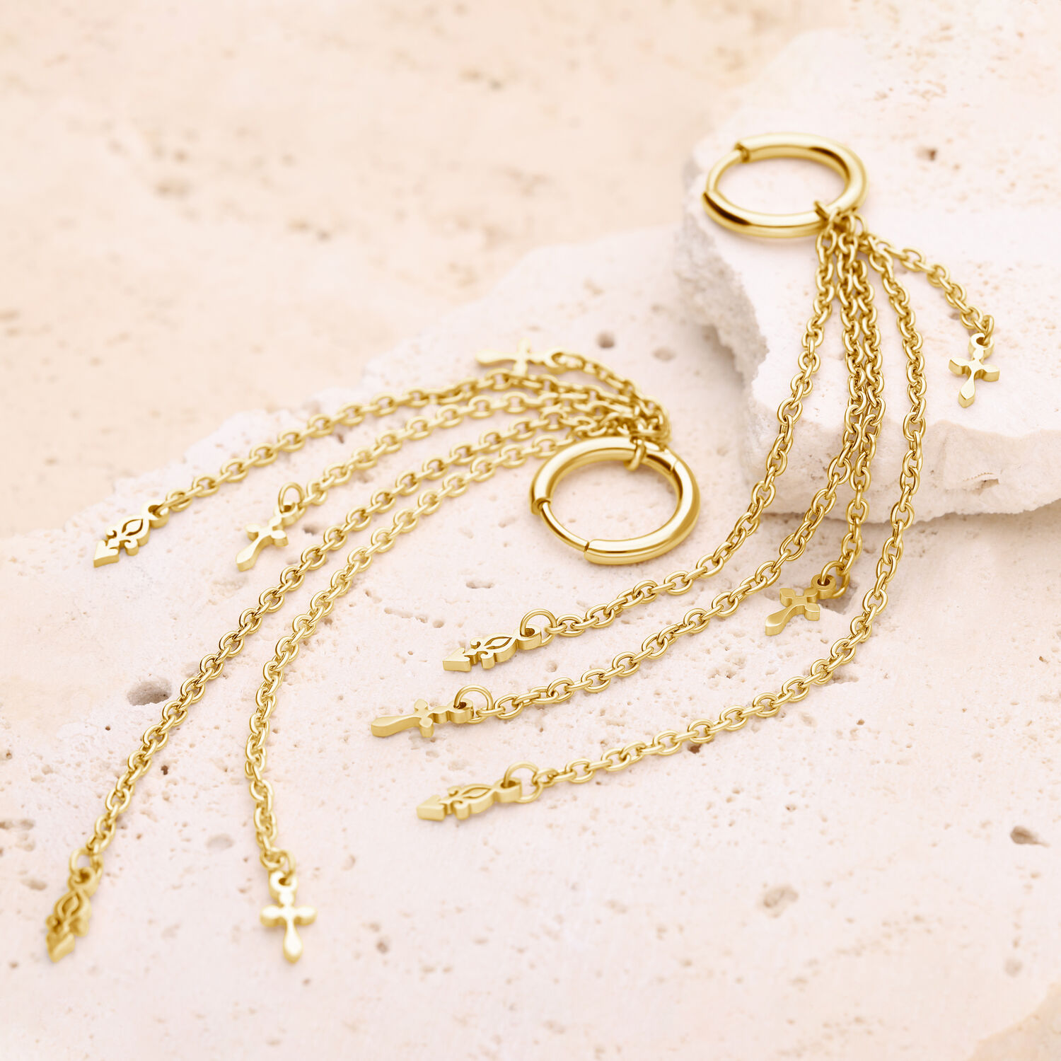 Pendientes dorados con colgantes de cadena Pendientes dorados con cadenas largas y finas y pequeñas cruces sobre piedra clara