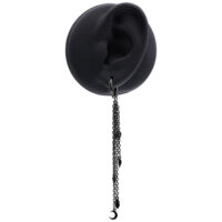 Pendiente de acero inoxidable negro con diseño de cadena Pendiente negro con cadenas largas en una oreja artificial sobre fondo blanco