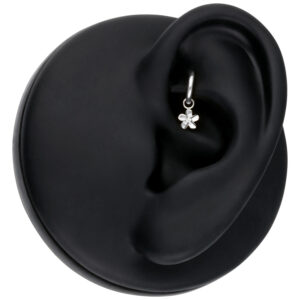 Colgante de flor plateada en un modelo de oreja negra, primer plano