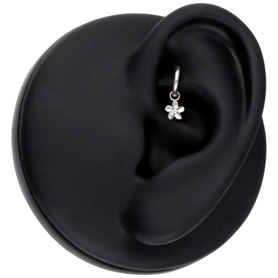 Colgante de flor plateada en un modelo de oreja negra, primer plano
