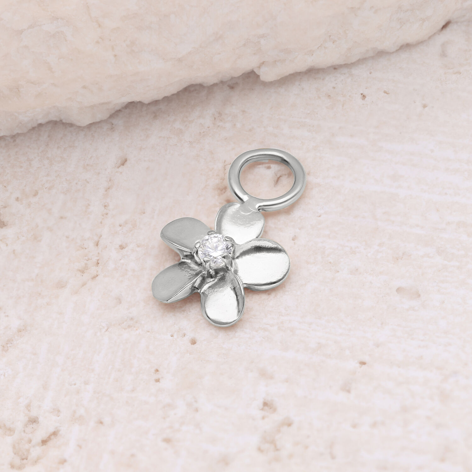 Colgante de flor plateada con circonita Colgante de flor plateada con circonita brillante sobre piedra clara