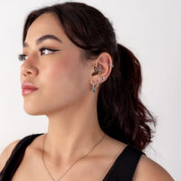 Mujer con varios piercings de oreja plateados, perfil lateral