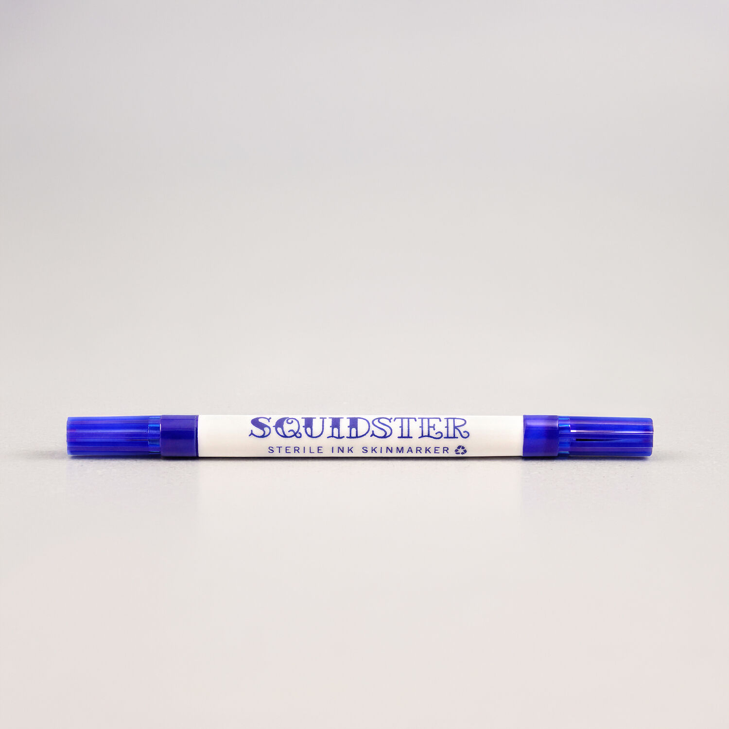 Marcador Mini Squidster de Tatuaje Azul Marcador de tatuaje azul de doble punta sobre fondo claro