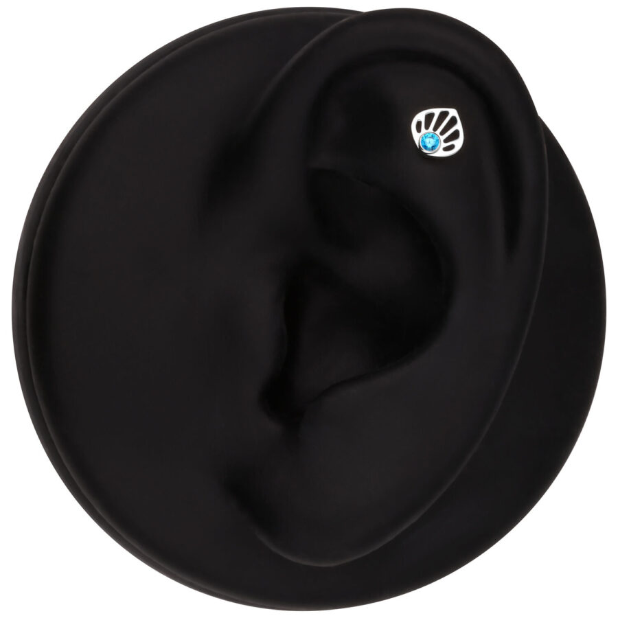 Modelo de oreja en oro blanco con cristal turquesa sobre fondo negro