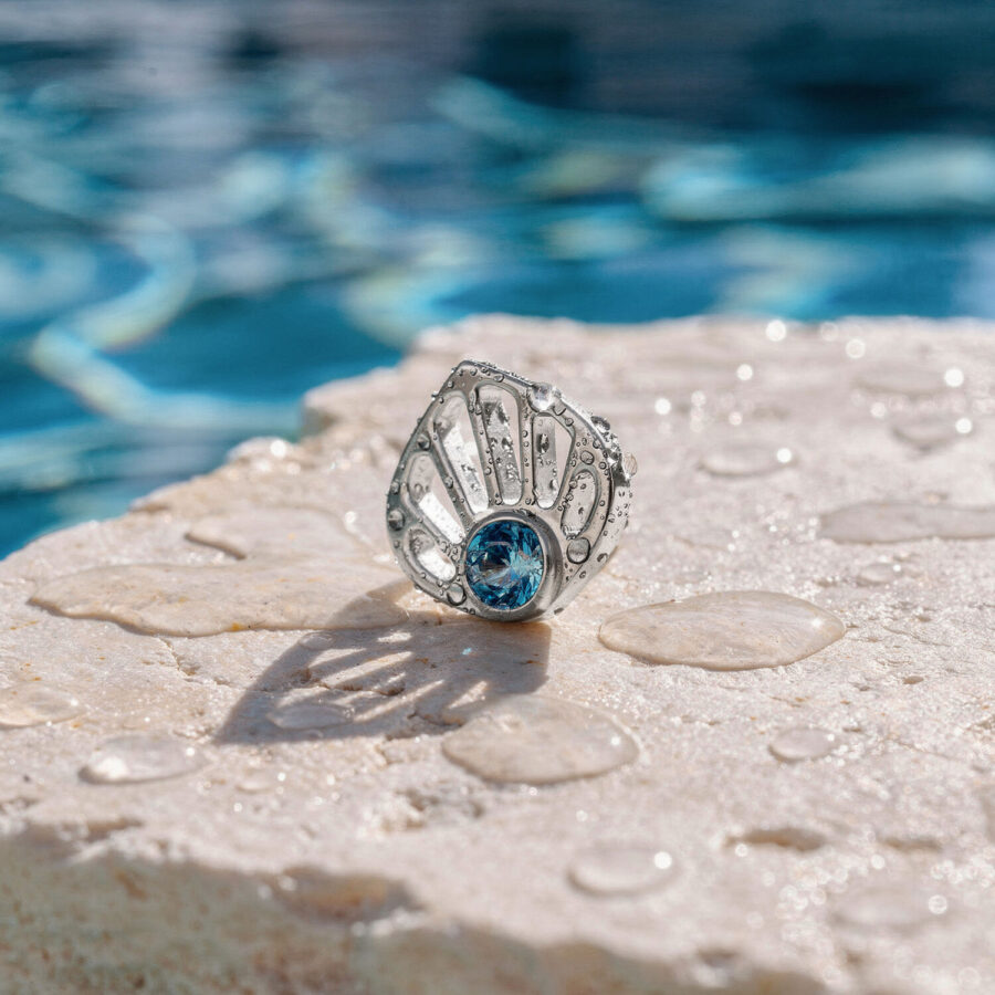 Ajuste de concha de oro blanco con cristal turquesa sobre una piedra mojada en la piscina