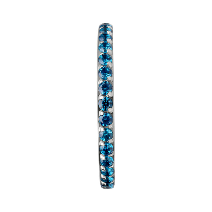 Anillo de piercing delgado con cristales turquesas sobre fondo blanco