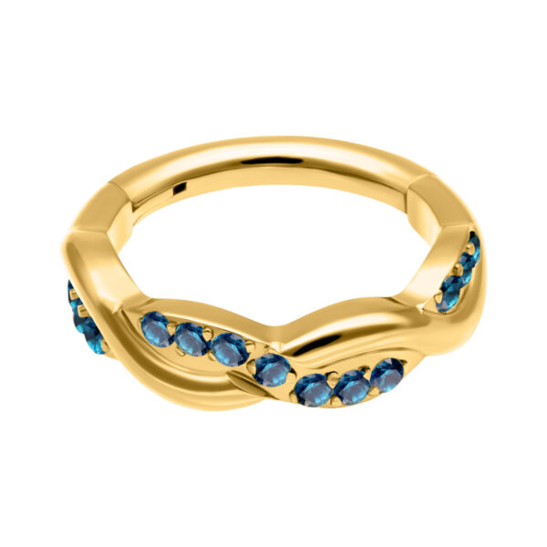 Anillo dorado con cristales turquesas sobre fondo blanco
