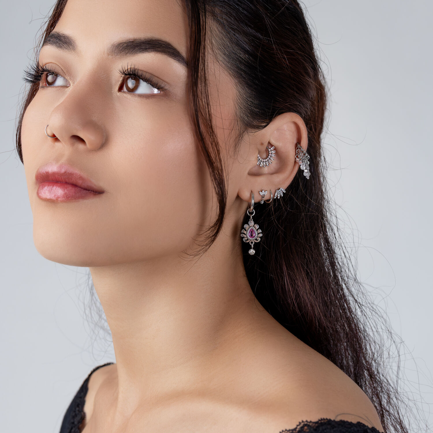 Juego de joyas de oreja plateadas con cristales Mujer posando de lado con juego de joyas de oreja plateadas y cristales