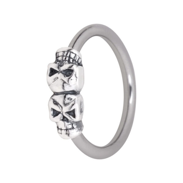 Aro clip in plateado con dos calaveras pequeñas sobre fondo blanco