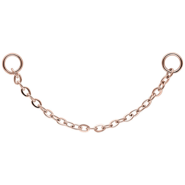 Cadena de oro rosa con dos anillos sobre fondo blanco
