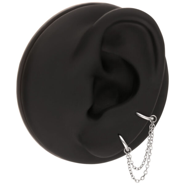Réplicas de oreja negra con cadena de conexión plateada, fondo de estudio