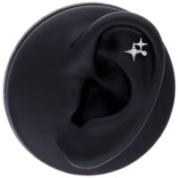 Aplique de piercing de estrella plateada en modelo de oreja negra sobre fondo blanco