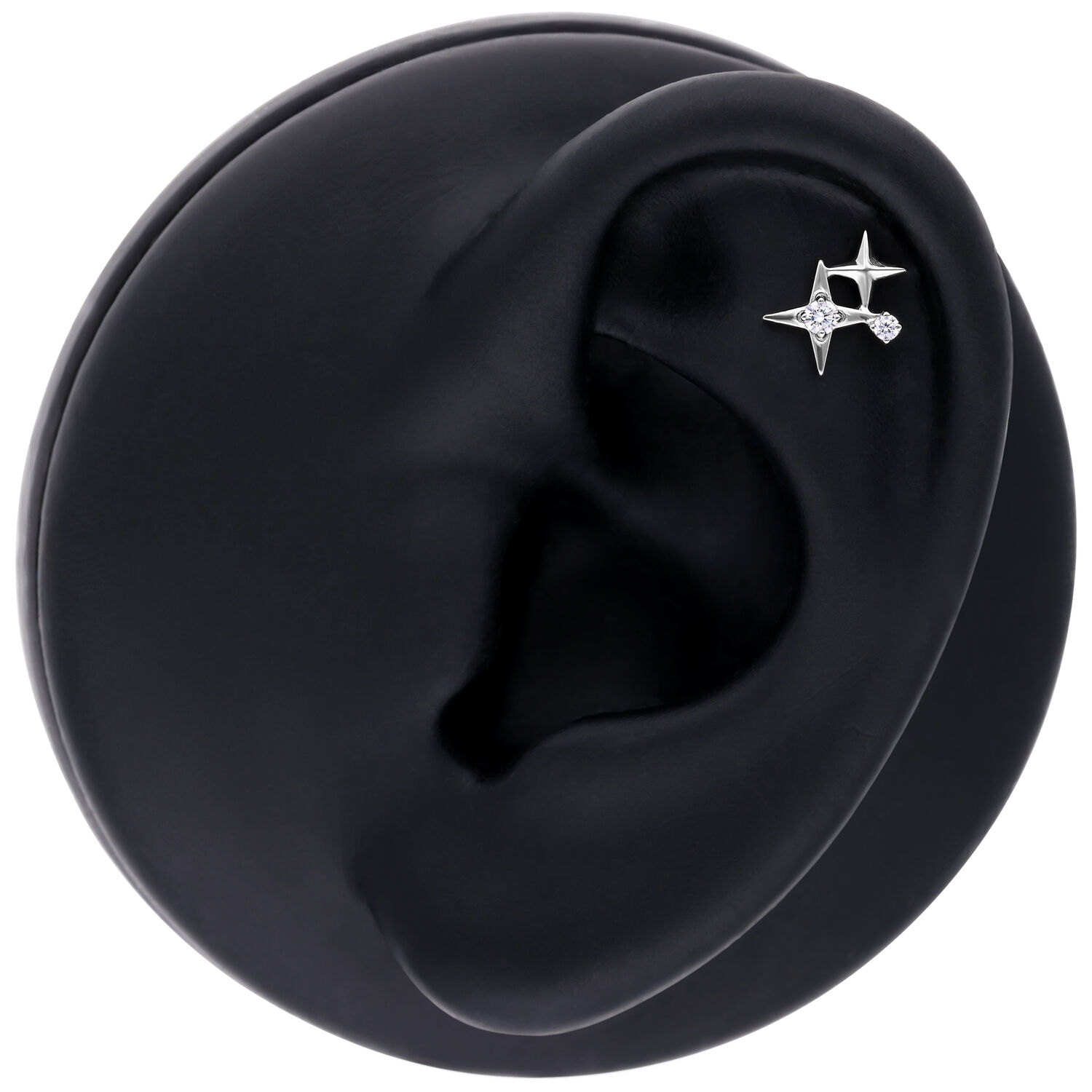 Aplique de piercing de estrella plateada en modelo de oreja negra sobre fondo blanco
