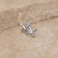 Pieza de estrella plateada con cristal claro sobre fondo de piedra beige