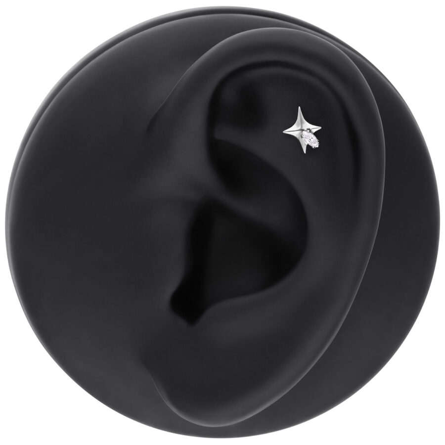 Piercing de estrella plateada con cristal claro en un modelo de oreja negra