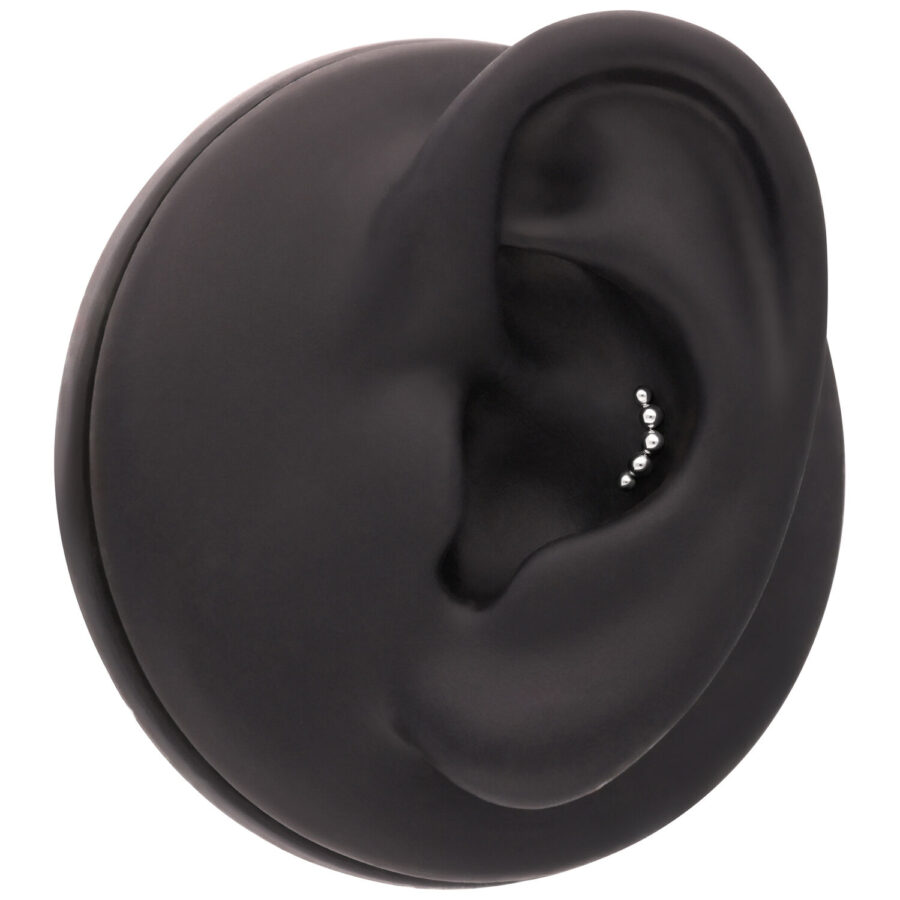 Accesorio negro para piercing de oreja con pequeñas bolas plateadas sobre fondo negro