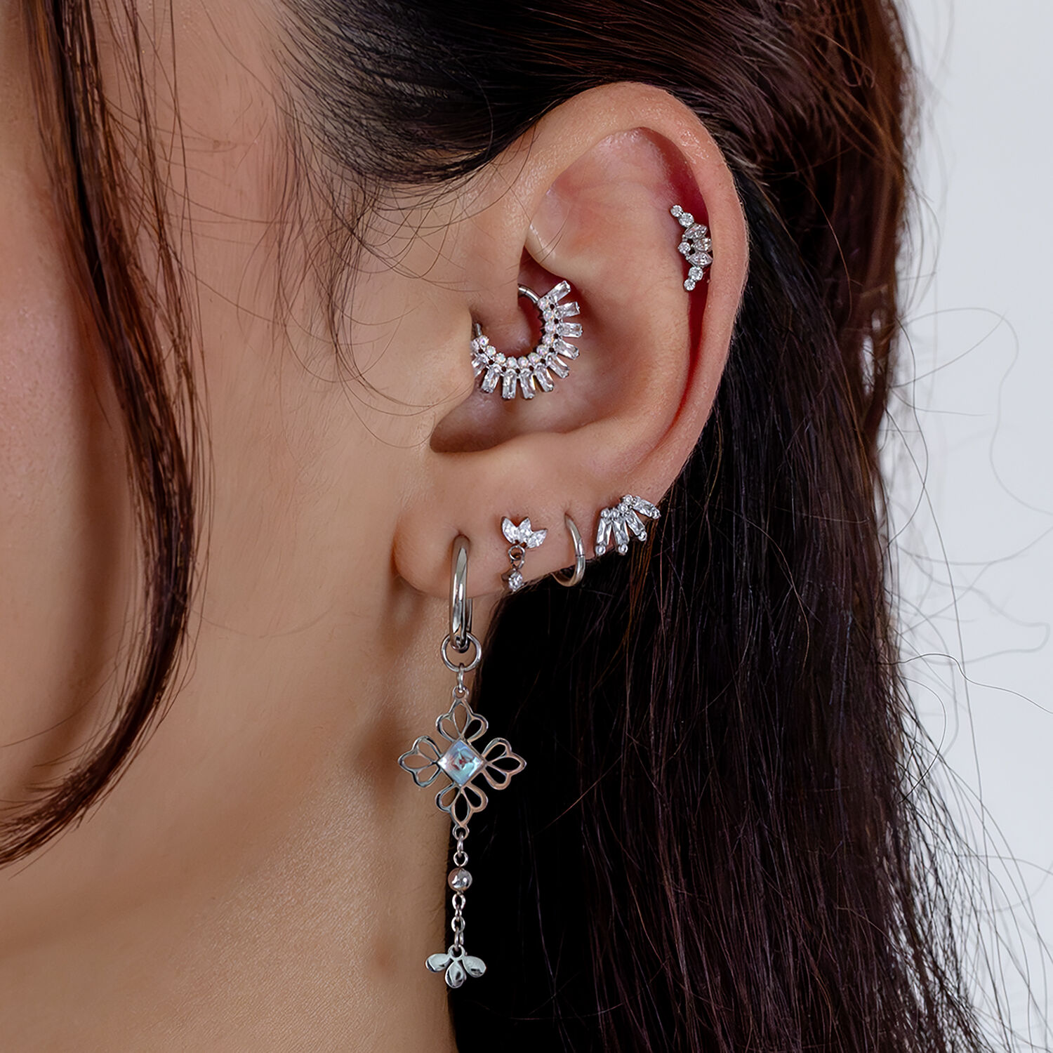 Piercings de oreja con tiara de cristal plateada Orejas con piercings de tiara plateada, varios diseños, sobre fondo blanco
