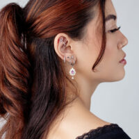 Accesorio de piercing de oreja plateado con cristal Mujer con varios pendientes plateados y un accesorio de cristal en la oreja, vista lateral