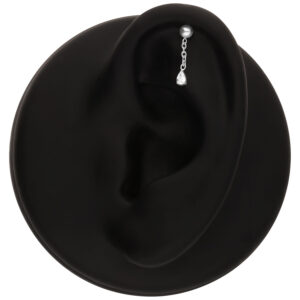 Aplique de piercing plateado con un cristal claro en un modelo de oreja negra