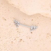 Barra de plata con alas de cristal sobre superficie de piedra beige