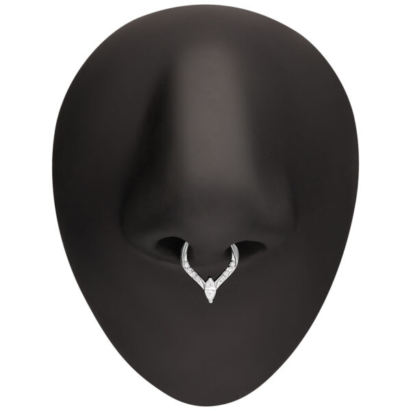 Anillo de piercing plateado con gota de cristal en una nariz falsa negra