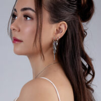 Mujer con accesorio de piercing plateado y cristales en la oreja, perfil lateral